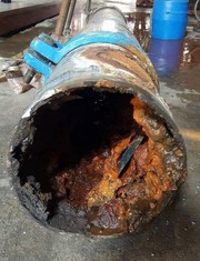 A rusty pipe with a hole in it

Description automatically generated